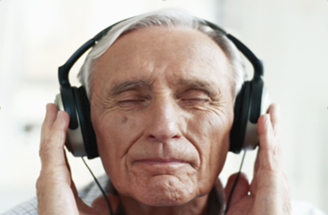 Tarifs : Un homme âgé écoute au casque une séance de musicothérapie réceptive